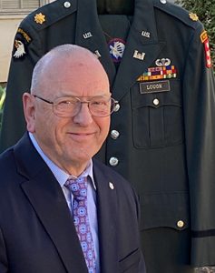 Tom Lough is pictured with his Army dress uniform in the background.